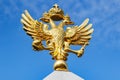 Moscow, Russia - September 13, 2019: Gilded russian double-headed eagle close-up in sunlight against blue sky. Obelisk in honor of