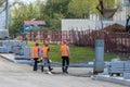 Moscow. Russia. September 06, 2020 Rear view of a group of construction workers wearing orange vests and safety helmets