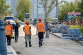 Moscow. Russia. September 06, 2020 Rear view of a group of construction workers wearing orange vests and safety helmets