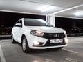 White Lada Vesta SW station wagon in an empty multi-storey car park at night.