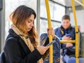 Moscow. Russia. September 16, 2020 A young girl stands on the bus with a smartphone in her hand and writes a message.