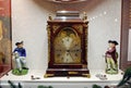 Darwin museum. Museum exhibits behind glass. Antique table clocks and porcelain vintage figurines.