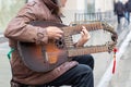 12-10-2019, Moscow, Russia. A street musician with an unusual guitar in his hands is playing in the streets of Moscow. Folk style Royalty Free Stock Photo