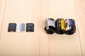 Three modern memory cards for a digital camera lie in a row on a table opposite three old 35 mm film for the camera Royalty Free Stock Photo