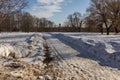 Winter landscape of the road, church and street lamp on background of blue sky.