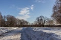 Winter landscape of the road, church and street lamp on background of blue sky.