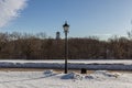 Winter landscape of the road, church and street lamp on background of blue sky.