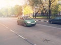 A woman drives a car at high speed. Green car drives fast through the city with motion blur effect. Overspeeding is not safe Royalty Free Stock Photo