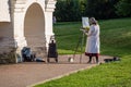A woman painting a picture in the open air. Hobby in the park.