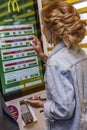 Moscow, Russia, 08/02/2019: Young beautiful woman in McDonald`s chooses food on an electronic board.