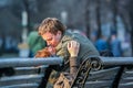 Young couple in love sitting on the bench in the park. Romantic kiss of young lovers. Royalty Free Stock Photo