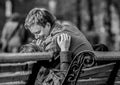 Young couple in love sitting on the bench in the park. Romantic kiss of young lovers. Royalty Free Stock Photo