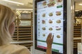 Moscow, Russia, 08/11/2019: Young woman chooses food on the screen at McDonald`s
