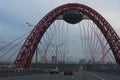 Hivopisny Bridge with cable-stayed red steel arch. Summer Day shot from a highway road with cars on Krasnopresnensky avenue