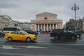 A stream of cars and yellow taxis travels fast against the backdrop of the Bolshoi Theater in Moscow 1