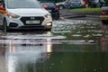 Taxi and cars in city traffic after heavy rain driving through flood Royalty Free Stock Photo