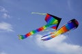 Two bright kites hover in the blue sky. Royalty Free Stock Photo