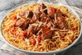 Moshari Kokkinisto or Tas Kebap Greek Veal Stew in a Tomato Sauce with pasta spaghetti closeup on the plate. Horizontal Royalty Free Stock Photo