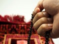Moslem man praying using wooden beads Royalty Free Stock Photo