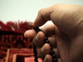 Moslem man praying using wooden beads Royalty Free Stock Photo