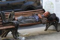 Homeless man sleeps on a bench