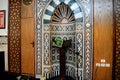 A mosque from inside with Islamic decorative style, mosque Mihrab or niche with a Quran put on a wooden stand and a microphone