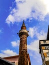 Mosque minaret in Istanbul Turkey close-up, vertical. Muslim tower with loudspeakers among city buildings against a blue sky - Royalty Free Stock Photo