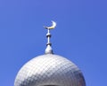 Mosque of Muslim. Crescent on copper covered dome and minaret of mosque against blue sky. Symbol of Islam and Ramadan.