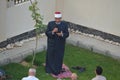 A mosque preacher Imam performs Eid Al Adha Khutbah (sermon) in an open air space near the mosque,