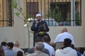 A mosque preacher Imam performs Eid Al Fitr Khutbah (sermon) in an open air space