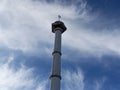 A mosque tower rises against a bright blue sky dotted with clouds Royalty Free Stock Photo