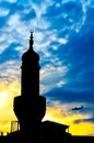 Mosque tower silhouette over the blue sky on dusk and a plain landing in background Royalty Free Stock Photo