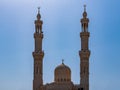 Mosque in the urban area. Dome and towers against a bright blue sky. Royalty Free Stock Photo