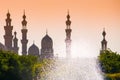 Mosques silhouettes against the yellow sky and sparkling fountain in Cairo