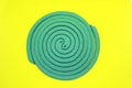 Mosquito coil protection against mosquitoes isolated on yellowish close-up background.