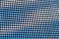 The mosquito net under magnification, against the background of a blue sky with white clouds. Royalty Free Stock Photo