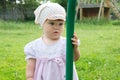 Mosquito stings baby`s finger in summer. Little girl looking at gnat on her hand and confused child Royalty Free Stock Photo