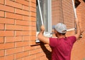 Mosquito wire screen installation. Contractor installing mosquito wire screen on house window to protect from insects Royalty Free Stock Photo