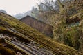 Moss-covered asbestos-shingle roof of ancient house on hillside Royalty Free Stock Photo