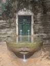 Mossy Face Fountain Beneath Carved Archway in Ruins Royalty Free Stock Photo