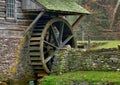Moss covered water wheel and stone retaining wall of a historic Royalty Free Stock Photo