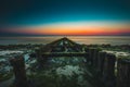 Moss covered wooden pier under the beautiful sky captured in Westkapelle, Netherlands Royalty Free Stock Photo