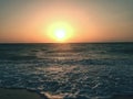 The most beautiful romantic setting of the sun over the sea, where the sun is already on the sea level with an interesting Royalty Free Stock Photo