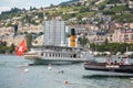 The most beautiful steam boat called La Suisse with Swiss flag waving at the stern approaching Montreux pier on Swiss Riviera,