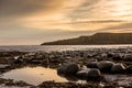 The most beautiful sunrise at Dunstanburgh Castle with the famous slippery black boulders in Northumberland, as the sky erupted wi Royalty Free Stock Photo