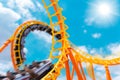 Most exciting roller coaster drive high to summer sky at theme park, people excited fun and joyful playing machine in holiday Royalty Free Stock Photo