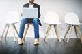 The most important part of an interview is your preparation. a young businessman using a laptop while waiting in line. Royalty Free Stock Photo