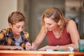 The most influential teacher is a parent. a young woman helping her son with his homework at home. Royalty Free Stock Photo