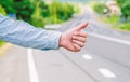 Most popular way of hitchhiking is to thumb up. Hand thumb up gesture try stop car road background. Thumb or hand Royalty Free Stock Photo