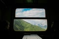 Girl looking at the window of a train on the Sarajevo-Mostar train line, at the moment tall mountains are visible.